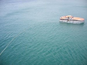 slowly pulling the boom towards the ship, while catching the "simulated" oil.